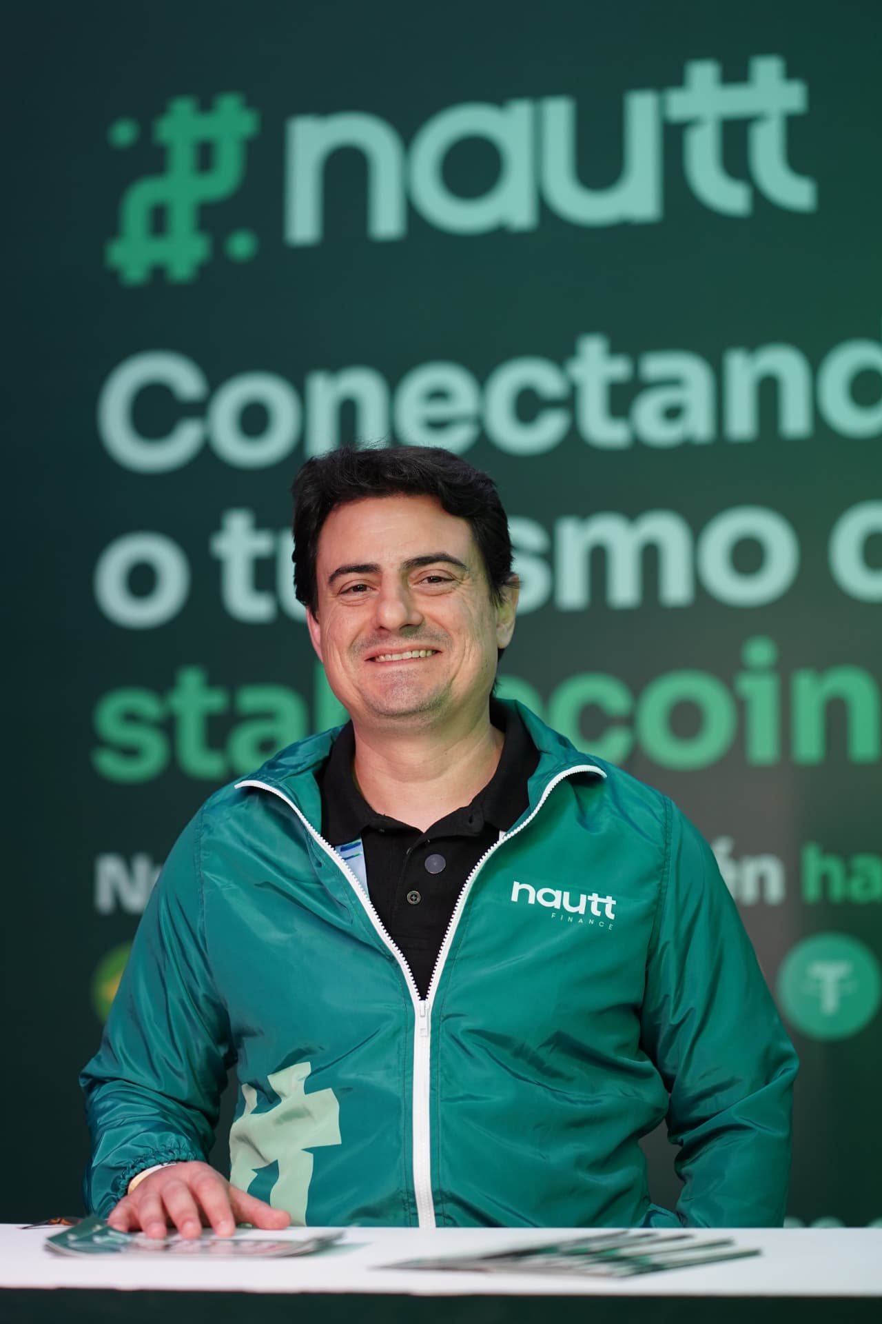 Integrante da equipe Nautt em frente à identidade da marca