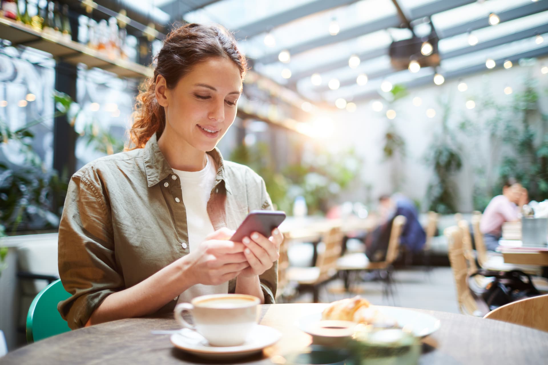Cliente utilizando o smartphone para pagar em um café